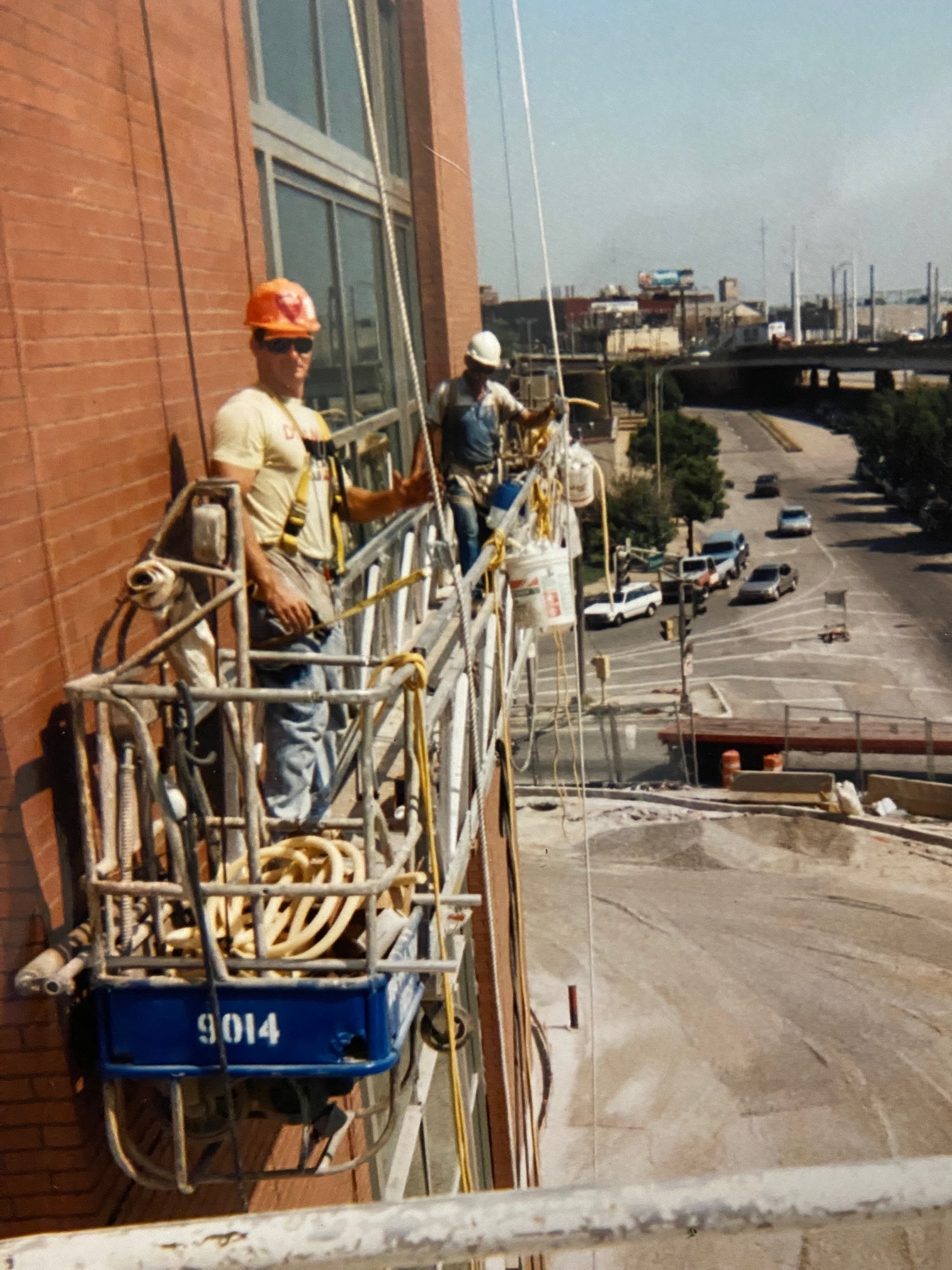 Sean and a coworker on a swing stage, installing the glass and aluminum curtainwall system on The Dome at America's Center in 1993.