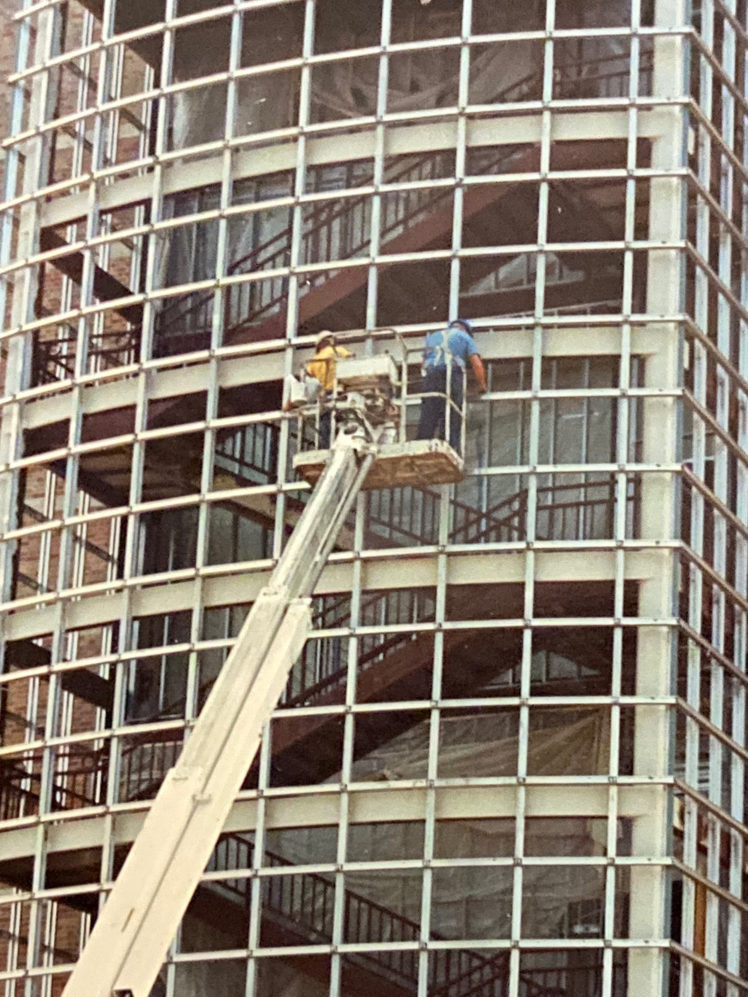 Glaziers on a MEWP installing the curtainwall installation at the Beckman Institute for Advanced Science and Technology on the U of I Campus in Urbana, Illinois – 1988-89