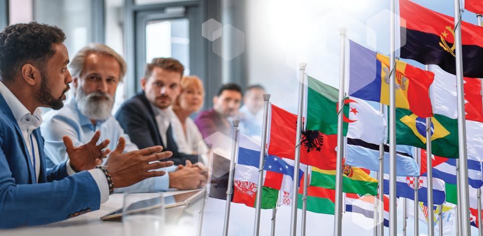 Image of global leaders in a board room setting along side an international grouping of flags.