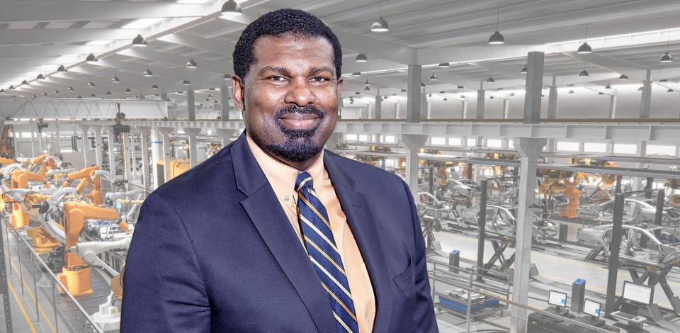 Professional headshot of Chuck Easley set on a robotics factory background. 