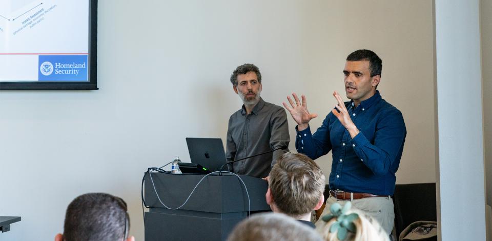 Two men giving a presentation at a cybersecurity conference.