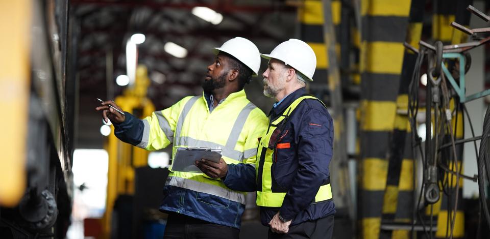Two manufacturing employees talking in a plant