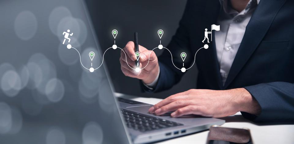 man working at a laptop with a graphic showing career transition flags