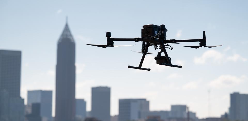 A large drone hovers in front of the Atlanta skyline
