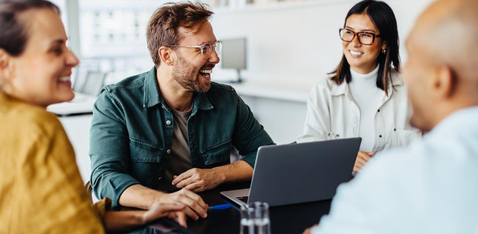 Group of people in a workplace smiling and laughing