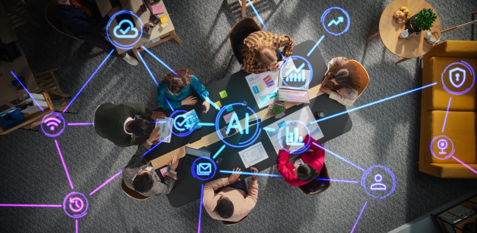 A team collaborates in an office while digital icons representing AI, connectivity, and cybersecurity appear throughout the workspace. 