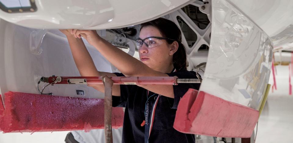 Spc. Victoria Frizalone adjusts the latches of the nosecone of a G450 at the Service Center of Gulfstream Aerospace.