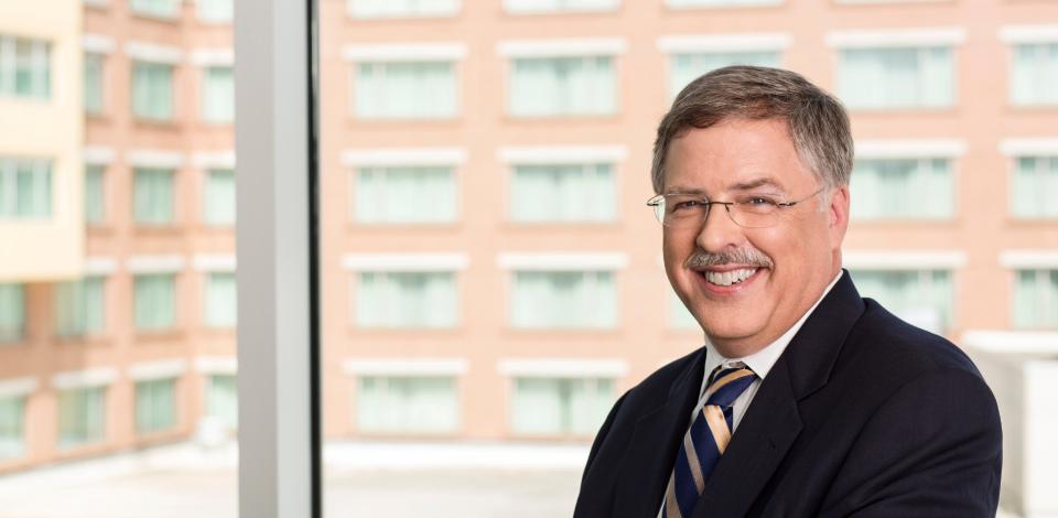 Nelson Baker smiling with the Global Learning Center behind him.