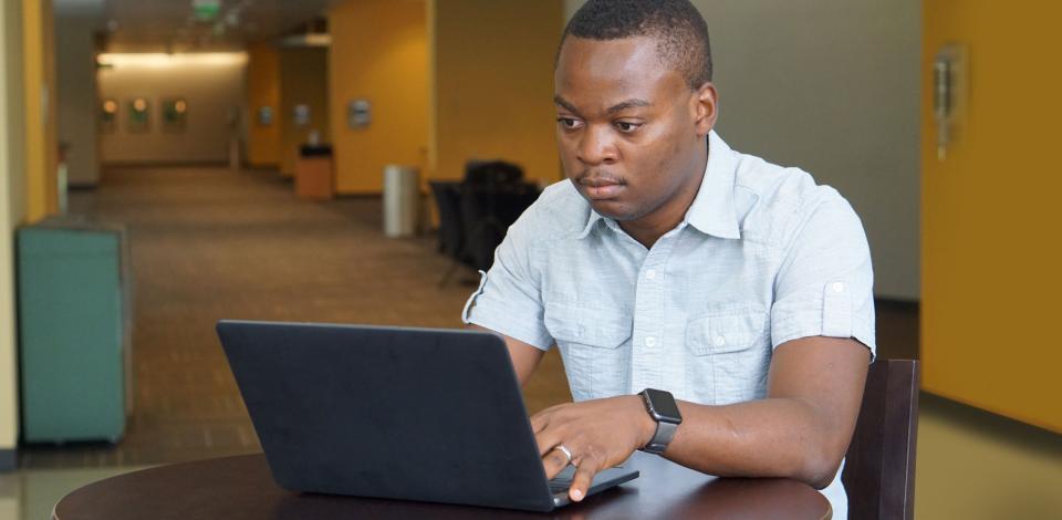 Esterling Accime working in front of laptop