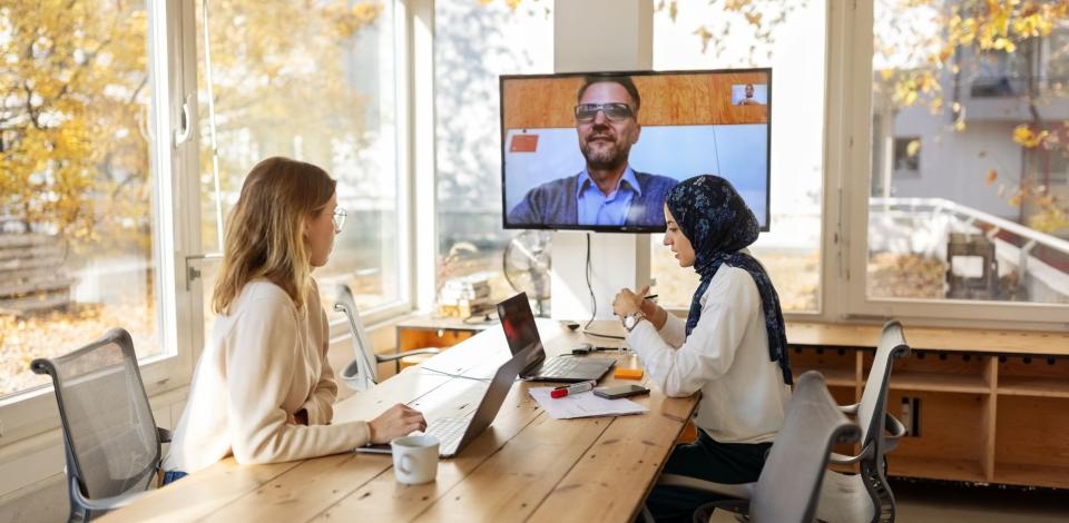 Business colleagues having a hybrid meeting while at the office.