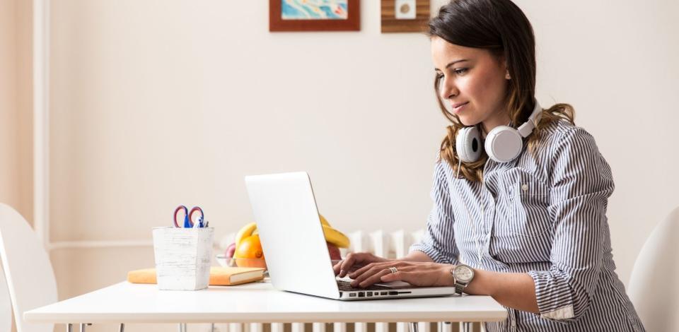 Adult professional reading blog content on laptop computer.