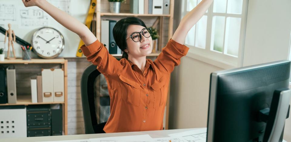 Female working professional taking a stretch break while working from home.