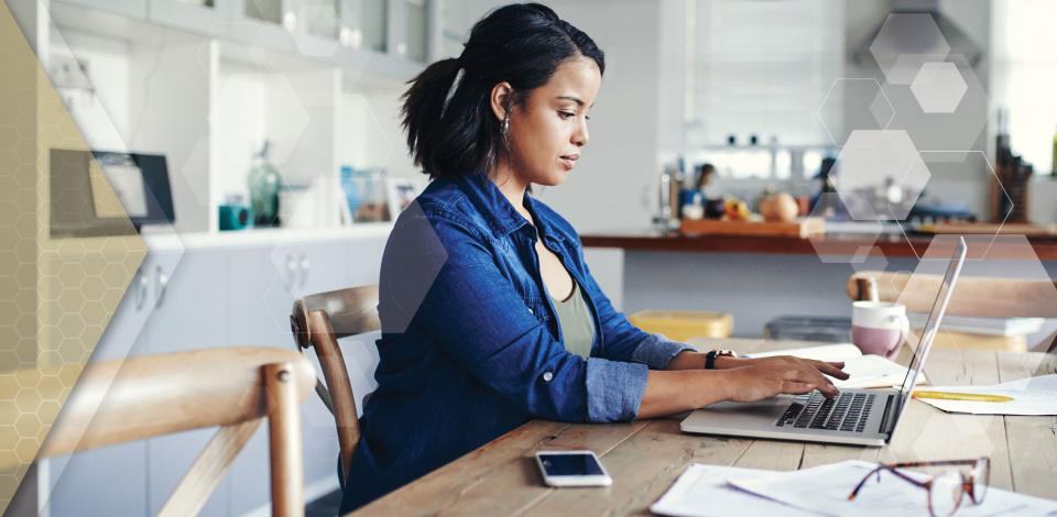 Remote worker using laptop computer and mobile phone to work from home.