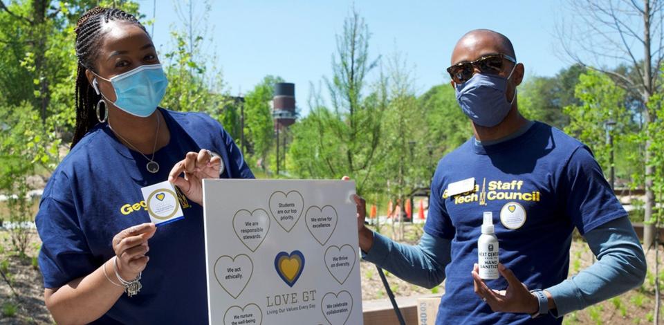 Georgia Tech employees holding up the nine organizational values on a poster board