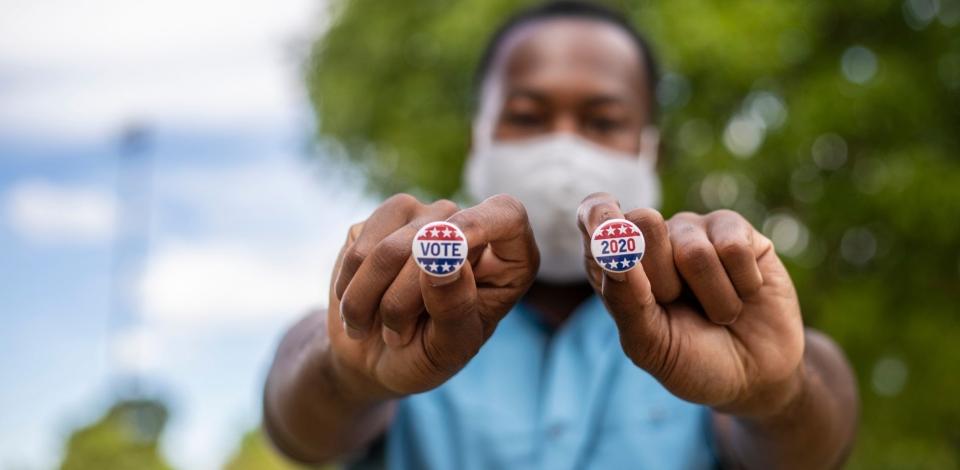 Male voter holding voting pins right after voting.