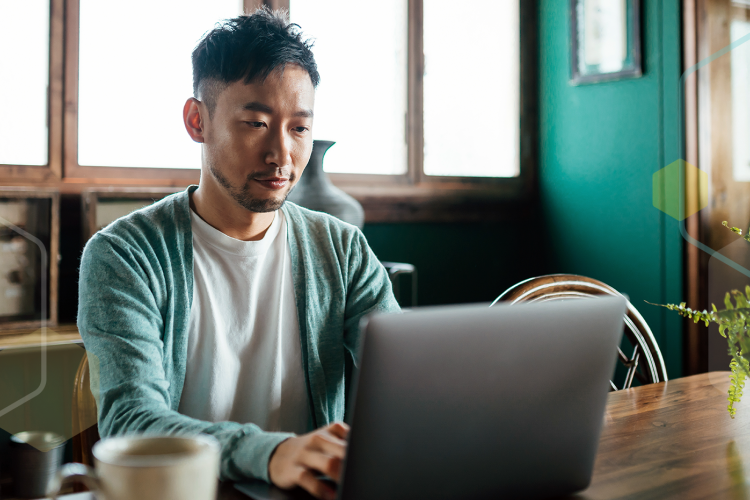 A man sitting at a table using a computer.