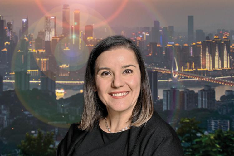 Claudia Scott's headshot over a background image of a city