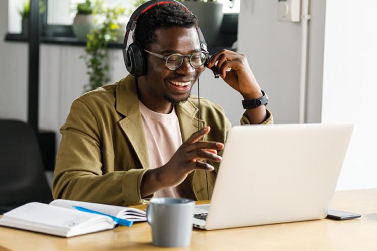 A man sitting at a computer holding a meeting virtually