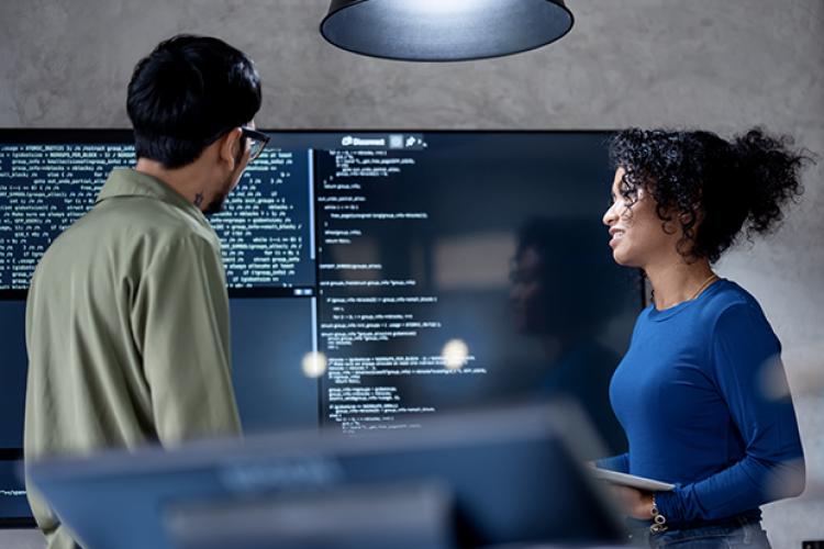 a man and woman discussing information on a computer