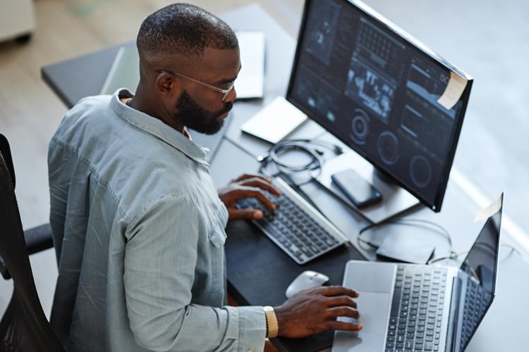 Business professional analyzing data on computer screens