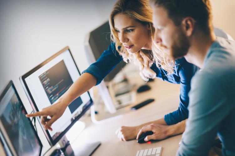 Male and female coding professional collaborating on computer