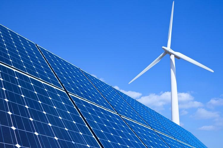 A  wind turbine producing energy alongside solar panel