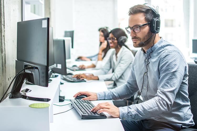 Man wearing phone headset on computer