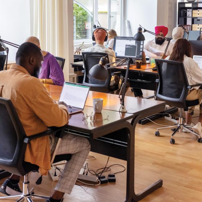 A group of people sitting at desks with computers