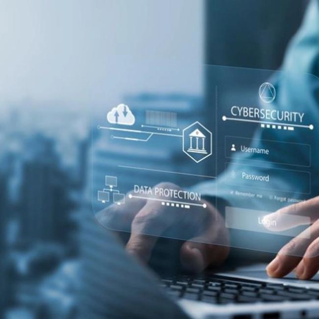 A close-up of a person typing on a computer that features cybersecurity-related icons.  