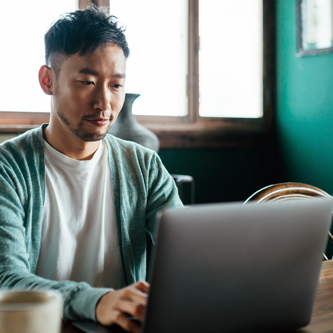 A man sitting at a table using a computer.
