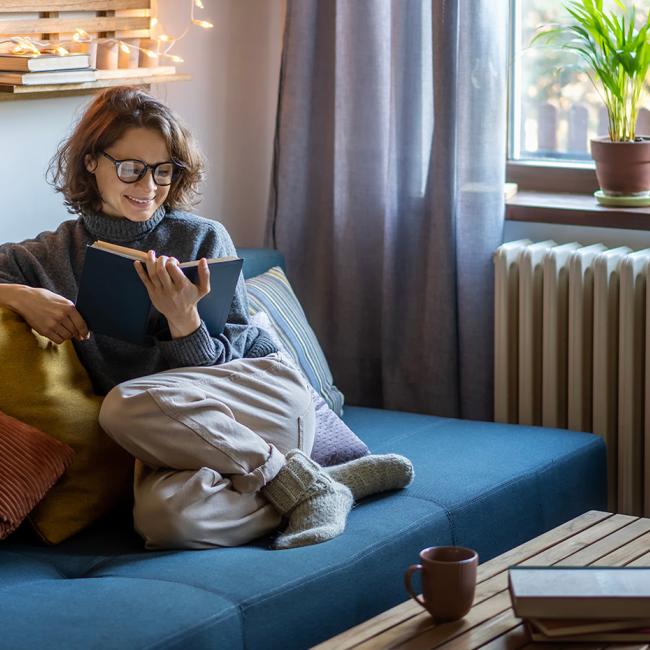 woman reading book in her living room