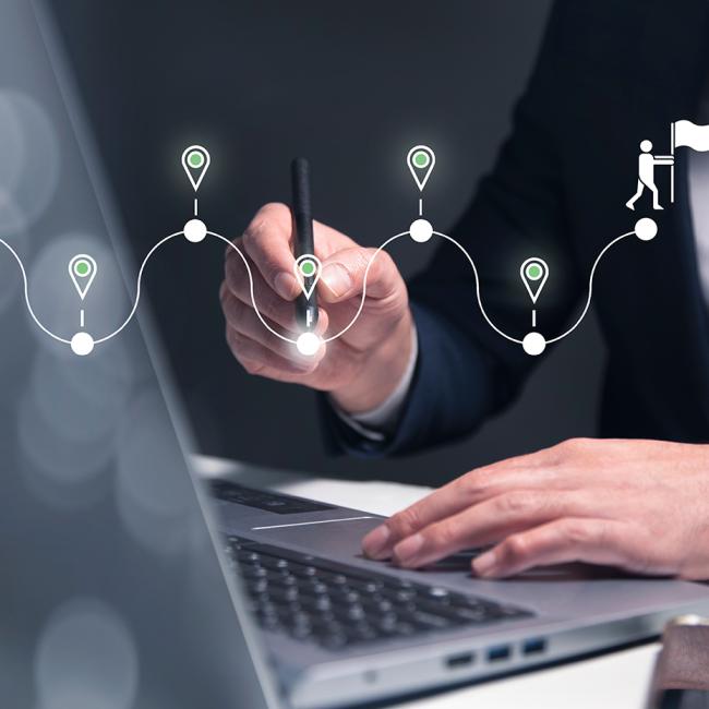 man working at a laptop with a graphic showing career transition flags