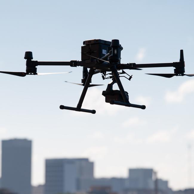 A large drone hovers in front of the Atlanta skyline
