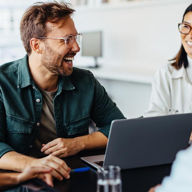 Group of people in a workplace smiling and laughing