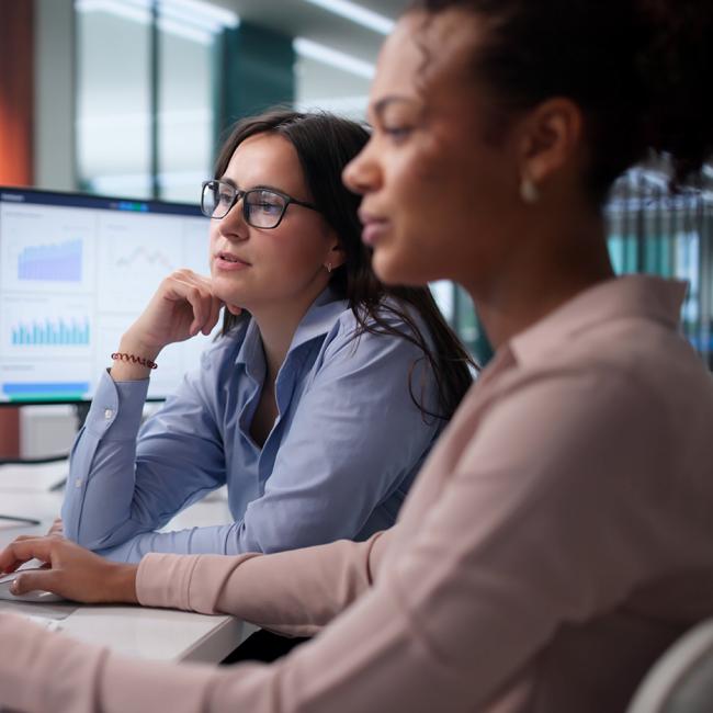 Two female business analysts reviewing data.