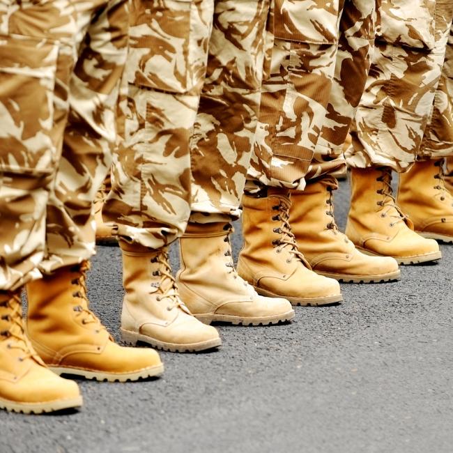 A close-up of soldiers legs in camouflage pants