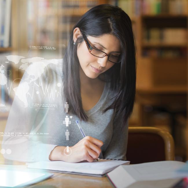 Woman looking over book with digital images in front of her