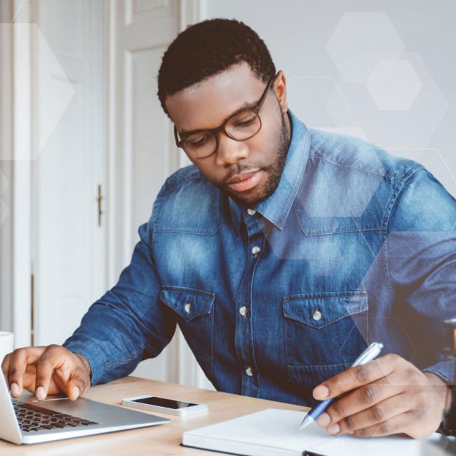 Remote worker using laptop computer and mobile phone to work from home.