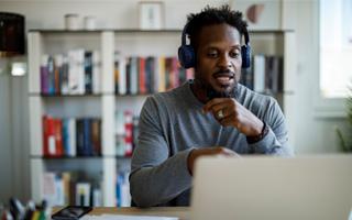 A person wearing headphones looking at a computer